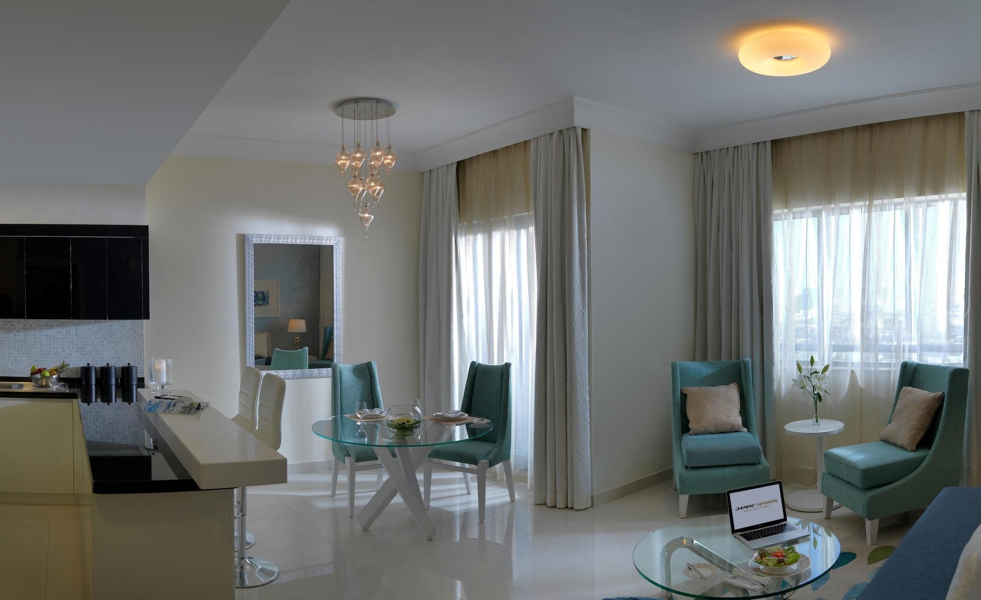 DAMAC Maison Dubai Mall Street Exterior foto The photo shows a modern, stylish living space. It features a bright and airy room with large windows dressed in light curtains that allow natural light to enter. The walls are painted in a soft color, and the floor has a glossy finish. 

In the cent