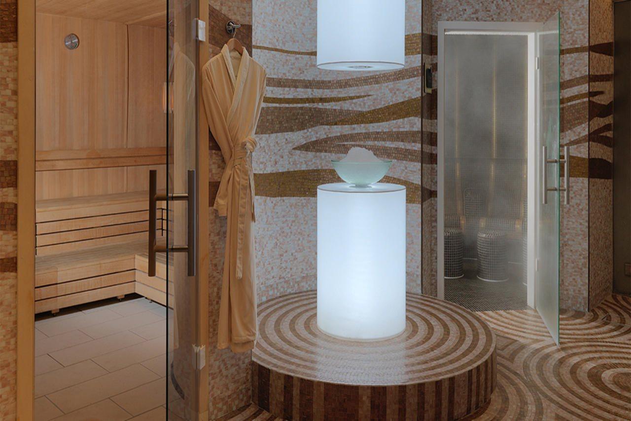 DAMAC Maison Dubai Mall Street Exterior foto The photo shows a modern spa area with a sleek and tranquil design. On the left side, there is a wooden sauna with benches for relaxation. In the center, there is a round pedestal with a softly glowing light, topped with a decorative bowl. The floor 